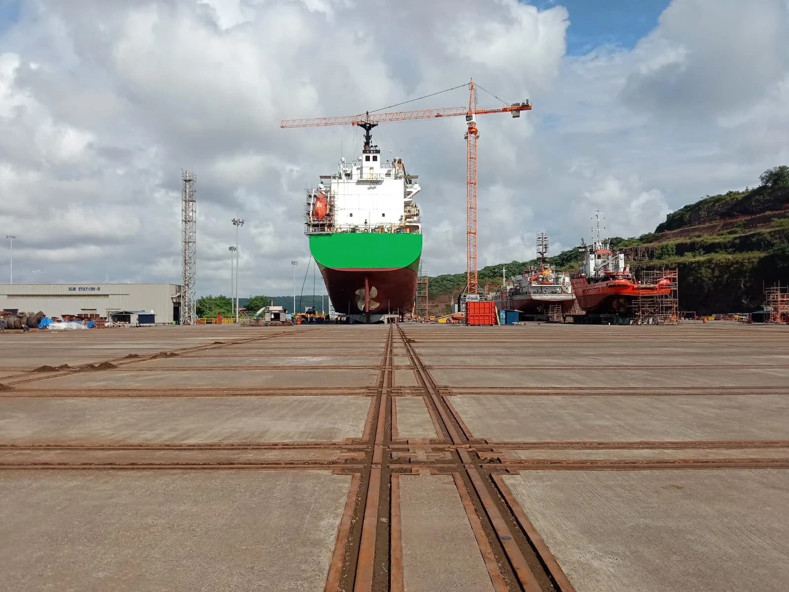 A vessel on a dockyard transfer yard with intersecting rail lines in the foreground